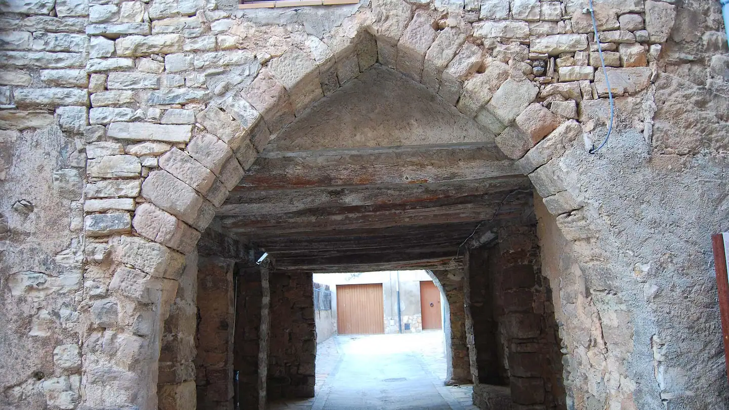 Arco de piedra medieval que da paso a una calle del pueblo