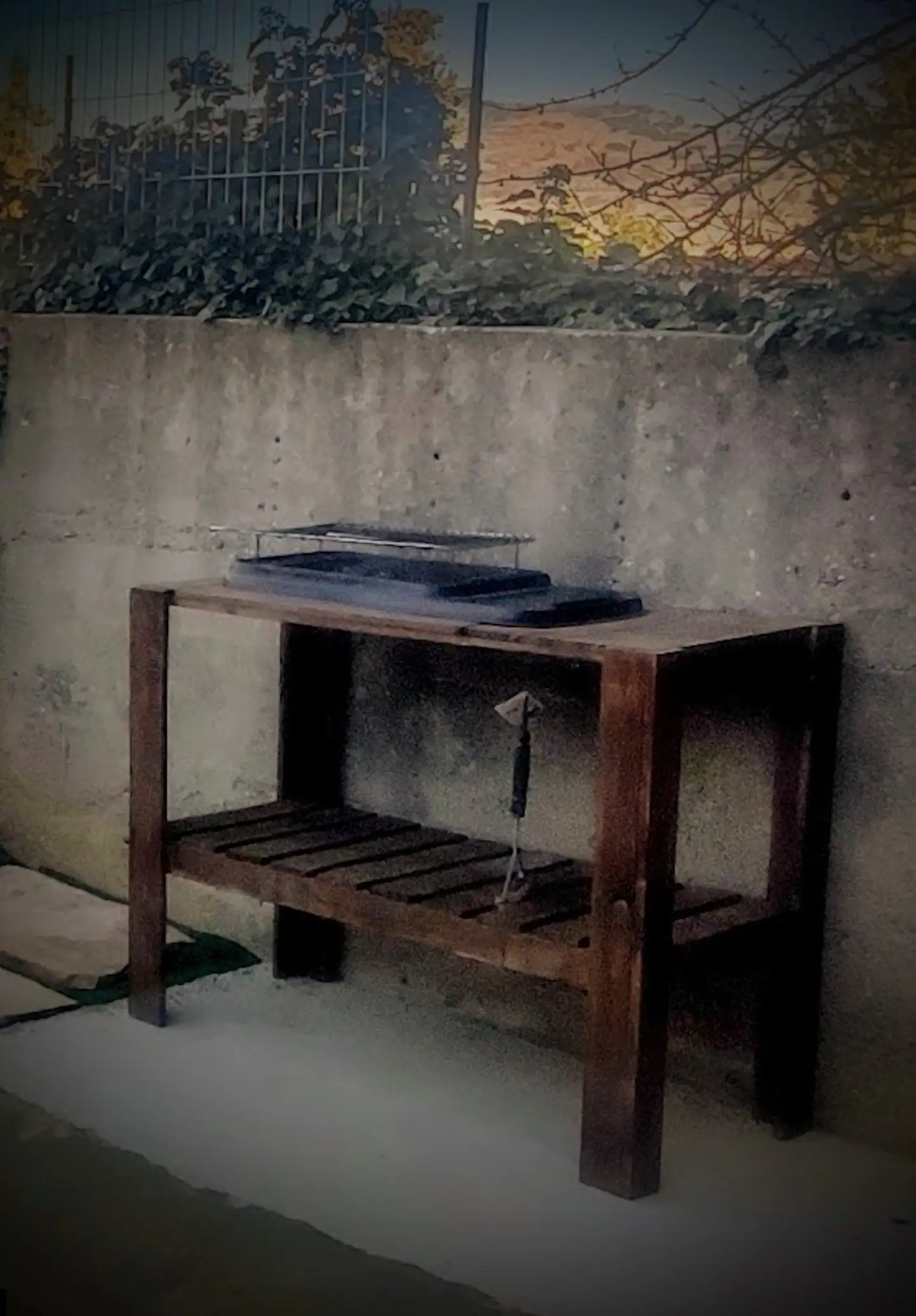 Barbacoa de obra con la mesa de trabajo de madera al lado